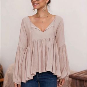 Light pink ruffly tie front babydoll top in a size M